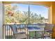 Screened balcony with seating, overlooking a peaceful lake and lush trees at 6816 Dali Ave # E206, Land O Lakes, FL 34637