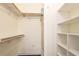 Walk-in closet with wood shelves and hanging rods for optimal storage space at 6816 Dali Ave # E206, Land O Lakes, FL 34637