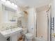 Clean bathroom with pedestal sink, shower and floating shelves at 7 Elgin Pl # 512, Dunedin, FL 34698