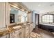 Elegant bathroom with double vanity, granite countertops, and soaking tub at 9203 Sea Oaks Ct, Seminole, FL 33776