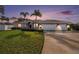 House exterior at dusk showcasing landscaping and garage at 9203 Sea Oaks Ct, Seminole, FL 33776