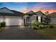 Gray house with white garage door and landscaping at 9846 Red Bay Loop, Land O Lakes, FL 34637