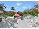 Spacious white deck with tables and chairs, overlooking the pool at 1 Gallinule Pl, Belleair, FL 33756