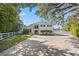 Two-story home with a brick paver driveway and a white picket fence at 1 Gallinule Pl, Belleair, FL 33756