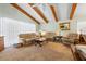 Living room with vaulted ceiling, exposed beams and neutral colored furniture at 1 Gallinule Pl, Belleair, FL 33756