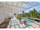 White pergola-covered deck with potted plants and pool view at 1 Gallinule Pl, Belleair, FL 33756