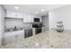 Modern kitchen with granite countertops and white cabinets at 1 Windrush Blvd # 100, Indian Rocks Beach, FL 33785