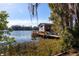 Rustic boat house with a wooden dock on the calm lake at 10106 Tarpon Springs Rd, Odessa, FL 33556