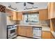 Galley-style kitchen with stainless steel appliances and wood cabinets at 10106 Tarpon Springs Rd, Odessa, FL 33556