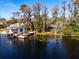 Picturesque waterfront view with dock and boat house, surrounded by trees at 10106 Tarpon Springs Rd, Odessa, FL 33556