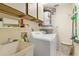 Laundry room with washer, dryer, utility sink, and storage at 1084 Dunrobin Dr # D, Palm Harbor, FL 34684