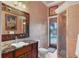 Bathroom featuring a vanity with a decorative mirror and a tiled walk-in shower leading to the pool at 1097 Eden Isle Ne Dr, St Petersburg, FL 33704