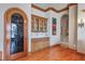 Elegant dining area with hardwood floors, custom cabinetry, and a decorative arched doorway at 1097 Eden Isle Ne Dr, St Petersburg, FL 33704