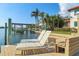 Waterfront home with dock, boat lift, and lounge chairs for relaxing by the water at 1097 Eden Isle Ne Dr, St Petersburg, FL 33704