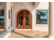 Outside view of an arched front door with large windows on either side in a white stucco wall at 1097 Eden Isle Ne Dr, St Petersburg, FL 33704