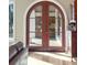 A wooden arched front door can be seen from inside a house with a cabinet off to the right at 1097 Eden Isle Ne Dr, St Petersburg, FL 33704