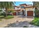 Beautiful Mediterranean-style home with a paver driveway, lush landscaping, and grand entrance at 1097 Eden Isle Ne Dr, St Petersburg, FL 33704