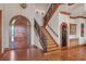 Elegant foyer featuring a staircase with wrought iron railings, hardwood floors, and stylish lighting at 1097 Eden Isle Ne Dr, St Petersburg, FL 33704