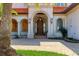 Elegant front entrance showcasing a grand archway, wooden door, and meticulous landscaping at 1097 Eden Isle Ne Dr, St Petersburg, FL 33704