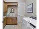 A laundry room with wood cabinets, granite counters, and modern washing machine at 1097 Eden Isle Ne Dr, St Petersburg, FL 33704