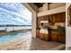 This covered patio includes an outdoor kitchen overlooking a swimming pool and the intercoastal waterway at 1097 Eden Isle Ne Dr, St Petersburg, FL 33704