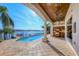 View of a lovely pool, outdoor kitchen, and private dock overlooking the water at 1097 Eden Isle Ne Dr, St Petersburg, FL 33704