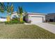 Single-story home with a two-car garage and lush landscaping at 13305 Waterleaf Garden Cir, Riverview, FL 33579