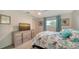 Well-lit bedroom with large windows, ceiling fan, and TV at 1366 Stafford Ln # 1420, Sarasota, FL 34232