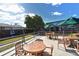 Outdoor dining patio with umbrella-covered tables and chairs in a fenced garden setting at 1366 Stafford Ln # 1420, Sarasota, FL 34232