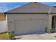 Attached garage with neutral color door and stone accents at 1418 Bluejack Oak Dr, Seffner, FL 33584