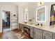 Elegant bathroom with double vanity, illuminated mirrors, hardwood floors, and a closet at 1893 Riveredge Dr, Tarpon Springs, FL 34689