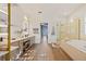 Bright bathroom featuring double vanity, tub, walk-in shower and hardwood floors at 1893 Riveredge Dr, Tarpon Springs, FL 34689