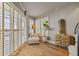 Bright sitting area with hardwood floors, stylish furniture, and large windows in the main bedroom at 1893 Riveredge Dr, Tarpon Springs, FL 34689