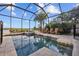 Screened in pool area with views of the water and a row of rocking chairs at 1893 Riveredge Dr, Tarpon Springs, FL 34689