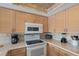 Well-equipped kitchen featuring white appliances and light wood cabinets at 19725 Gulf Blvd # 405, Indian Shores, FL 33785