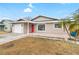 Updated home exterior with red door and landscaped yard at 210 Lee St, Oldsmar, FL 34677