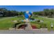 Community entrance with a large globe fountain and landscaping at 2363 Israeli Dr # 61, Clearwater, FL 33763