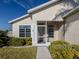 Front view of a tan house with a screened porch and manicured landscaping at 24156 Buckingham Way, Punta Gorda, FL 33980