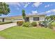 Updated exterior of a light-green single-story home with a two-car garage and nicely landscaped yard at 2421 Lancaster Dr, Sun City Center, FL 33573