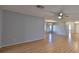 Living room with light-grey walls and laminate flooring; view of dining area and sliding doors at 2421 Lancaster Dr, Sun City Center, FL 33573