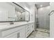 Bright bathroom featuring double vanity, quartz countertop, and modern shower with gray tiling at 2511 N Grady Ave # 23, Tampa, FL 33607