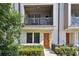 Townhome exterior featuring an orange front door, balcony, and walkway at 2511 N Grady Ave # 23, Tampa, FL 33607