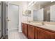 Double vanity bathroom with wood cabinets and tile floor at 26914 Juniper Bay Dr, Wesley Chapel, FL 33544