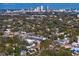 Overhead shot of a residential neighborhood with lush trees and city buildings afar at 3107 W Palmira Ave, Tampa, FL 33629