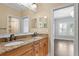 Bathroom with double vanity, granite countertop, and framed mirror, with an entrance to the walk-in shower at 3107 W Palmira Ave, Tampa, FL 33629