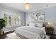 Bedroom featuring hardwood floors, modern chandelier, and a large window with shutters at 3107 W Palmira Ave, Tampa, FL 33629