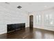 Well-lit bonus room with decorative wood accent wall, hardwood flooring, shutters, and built-in storage at 3107 W Palmira Ave, Tampa, FL 33629