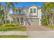 Inviting front exterior of a two-story house with a tile roof, pillars, and a brick driveway at 3107 W Palmira Ave, Tampa, FL 33629