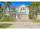 Two-story home with white stucco exterior, red tile roof, an attached two car garage, and landscaped front yard at 3107 W Palmira Ave, Tampa, FL 33629