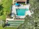 Aerial shot of a sparkling swimming pool, palm trees, and shuffleboard courts offering a relaxed resort-style living experience at 3124 Highlands Blvd, Palm Harbor, FL 34684